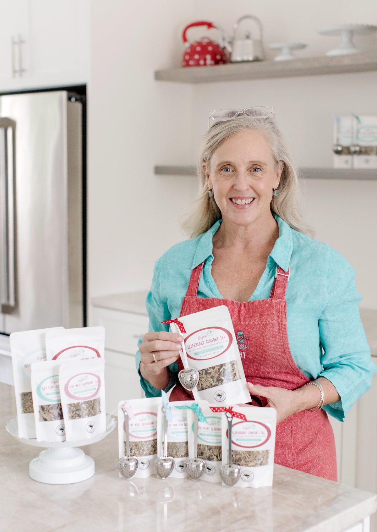 Minde Herbert, the owner of Sea Island Organics, stands in her kitchen holding her elderberry teas.